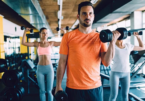 Members lifting weights together on the Choice Health & Fitness fitness floor